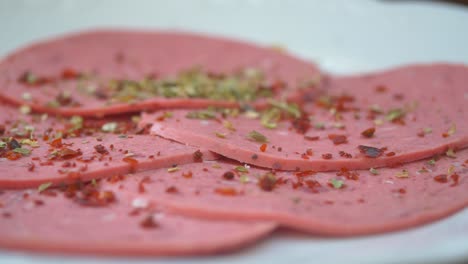 closeup of sliced salami with herbs and spices