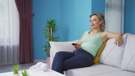 a la mujer que ve la televisión le gustan y aprueban las noticias.