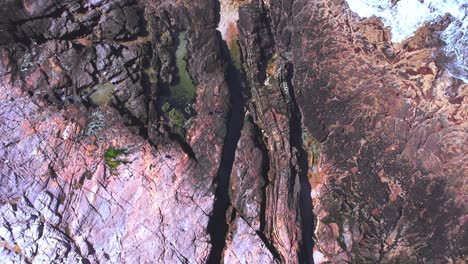 Zooming-out-from-the-shore-showing-the-expanse-of-the-rocky-shoreline-with-waves-at-bahia-bustamante