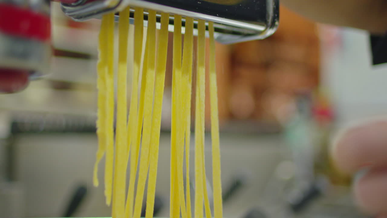 Pasta cutting machine makes traditional italian pasta, fettuccine.