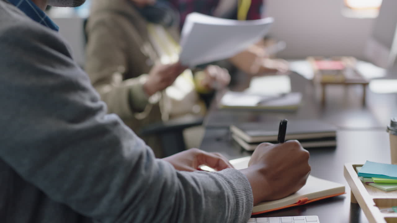 feliz hombre de negocios afroamericano leyendo documentos corporativos haciendo lluvia de ideas escribiendo notas usando la estrategia de planificación por computadora disfrutando de una carrera exitosa en una moderna empresa de comunicación de inicio
