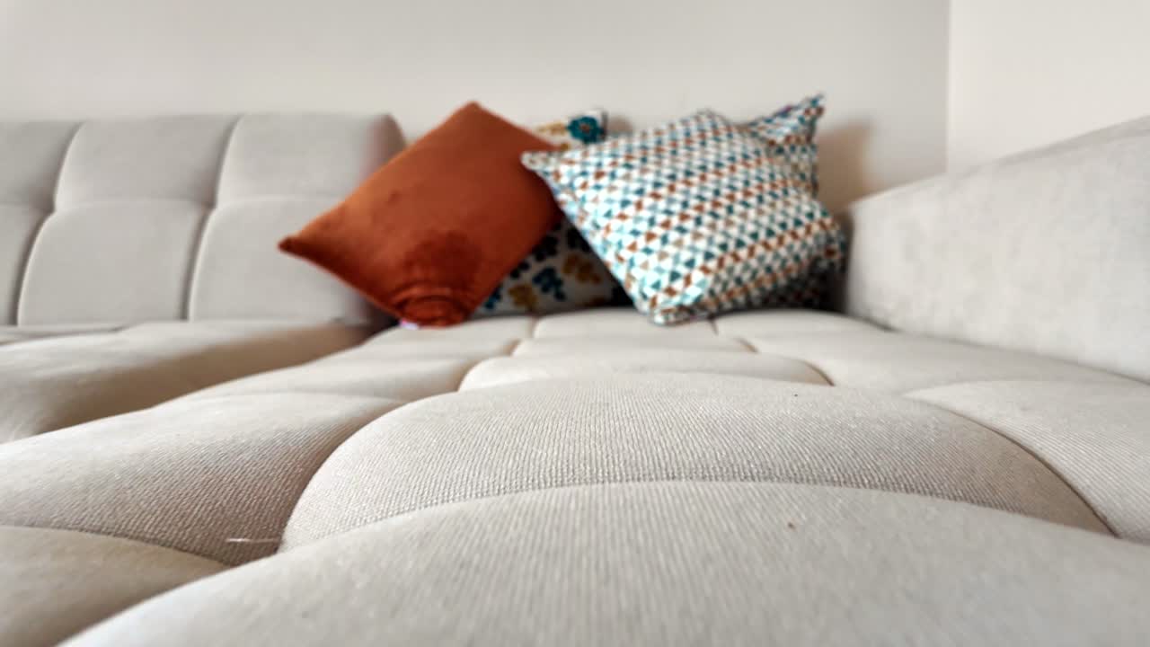 sofá seccional beige con almohadas de colores