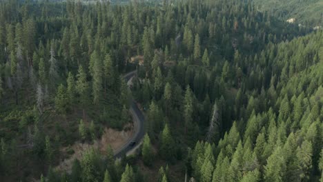 Imágenes-De-Drones-De-Una-Sinuosa-Carretera-De-Montaña-En-Las-Montañas-De-Dientes-De-Sierra-Con-Un-Automóvil-Conduciendo