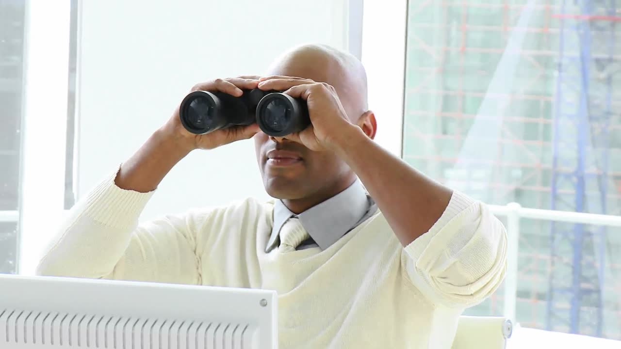 Ethnic businessman looking through binoculars