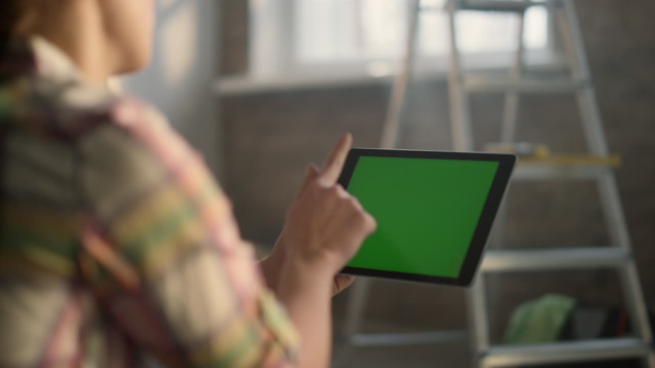 새로운 아파트에서 집 개조를 위해 태블릿을 사용하는 알아볼 수 없는 사람들이 있습니다.