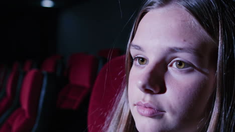 teenager watching a movie in a cinema