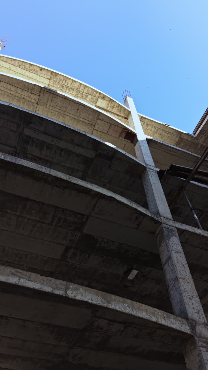 Exploración de la luz del día que ilumina el esqueleto de un edificio abandonado en un entorno urbano, revelando la belleza de la decadencia y la construcción