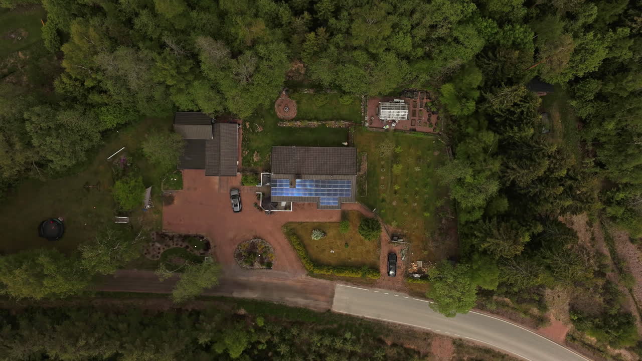 Ovenfra time-lapse af skyer, der bevæger sig over reflekterende solpaneler på et hus