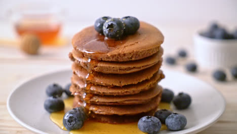 Pila-De-Panqueques-De-Chocolate-Con-Arándanos-Y-Miel-En-Un-Plato