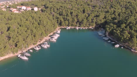 drone fly over a small hidden harbour in the adriatic sea croatia with wild nature and luxury yacht boat