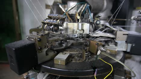 automatic socks machine producing socks from cotton thread - close-up parts of a garment production machine