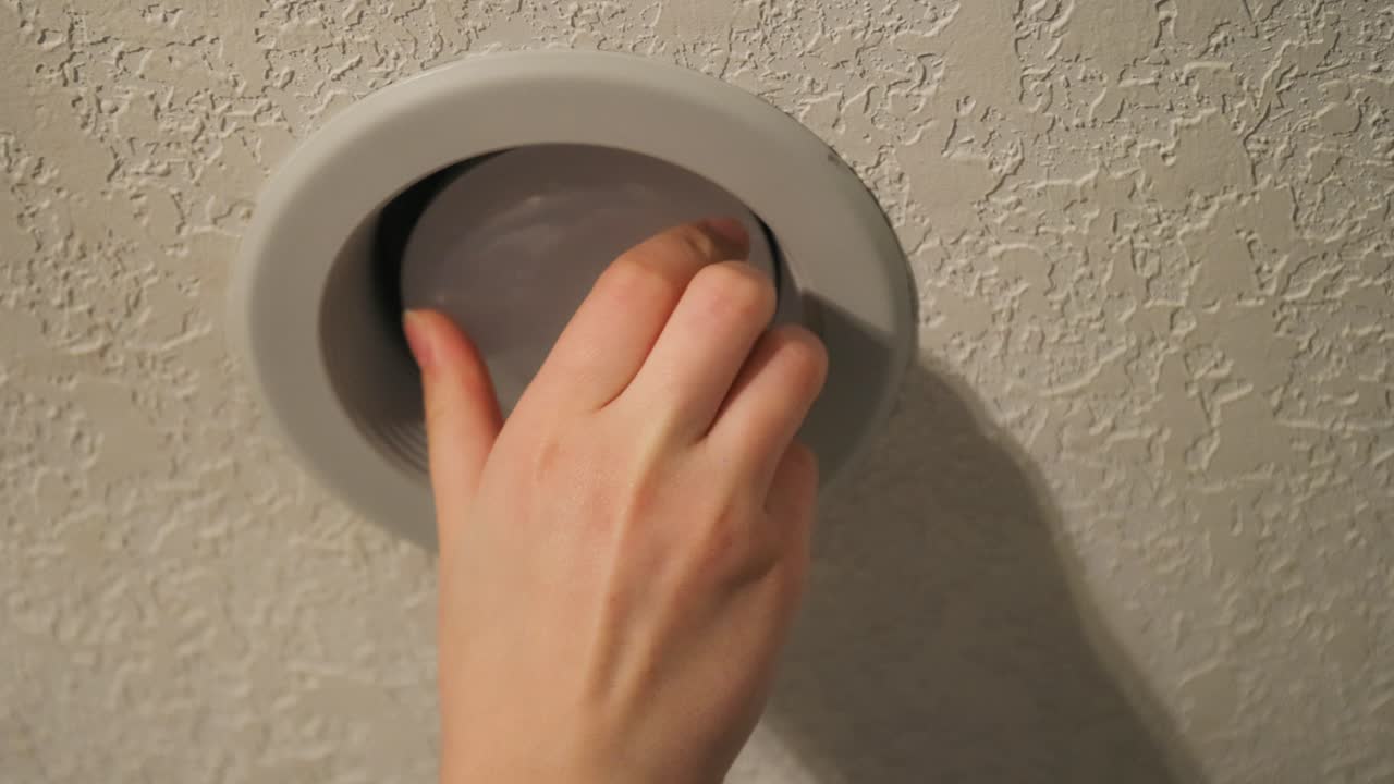 un primer plano de una persona instalando una bombilla