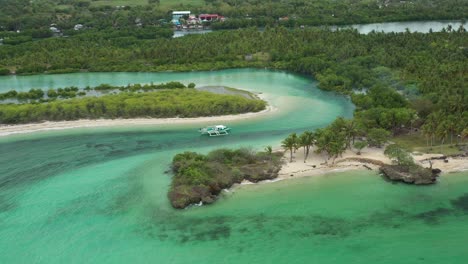 4k-Tracking-drone-shot-on-a-moving-Filipino-native-boat-in-a-stunning-calm-and-quiet-blue-lagoon