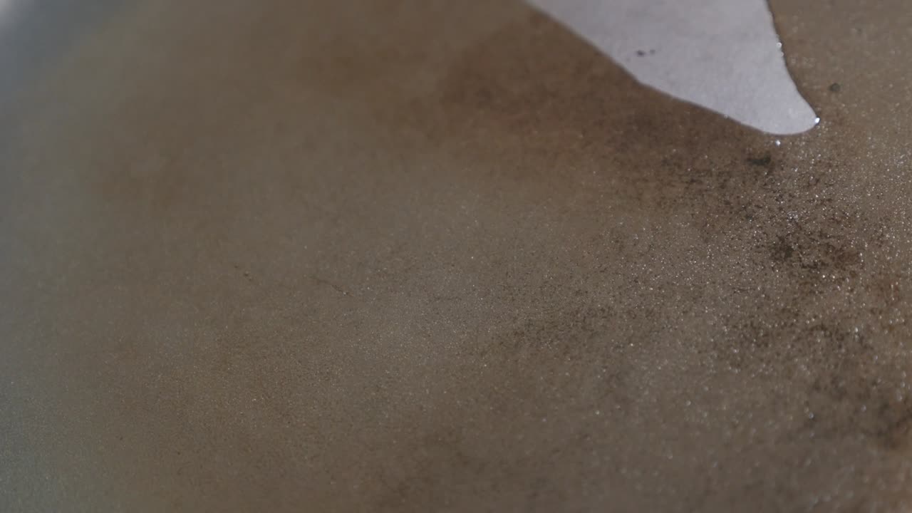 김판 표면에 식물성 기름을 뿌리는 클로즈업