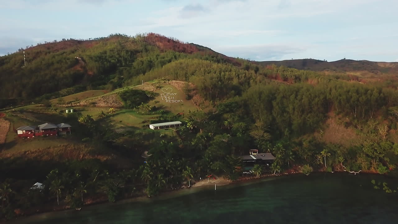 fiji drone funky fish vacaciones vacaciones malalo isla nadi resort temporada seca arrecife de coral acuático azul profundo paisaje montañoso soleado hermoso relajante paraíso de surf aéreo movimiento cinematográfico hacia adelante