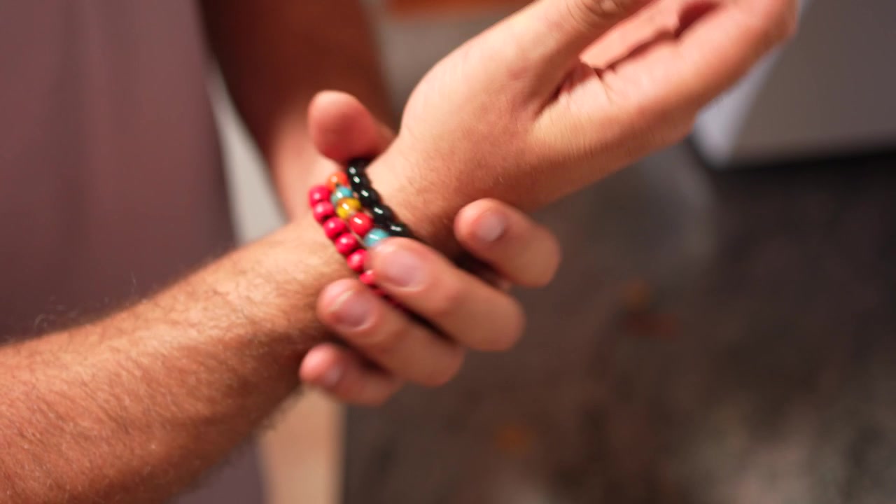 Una vista ravvicinata e dettagliata di braccialetti di perline vivaci e colorati che adornano un braccio