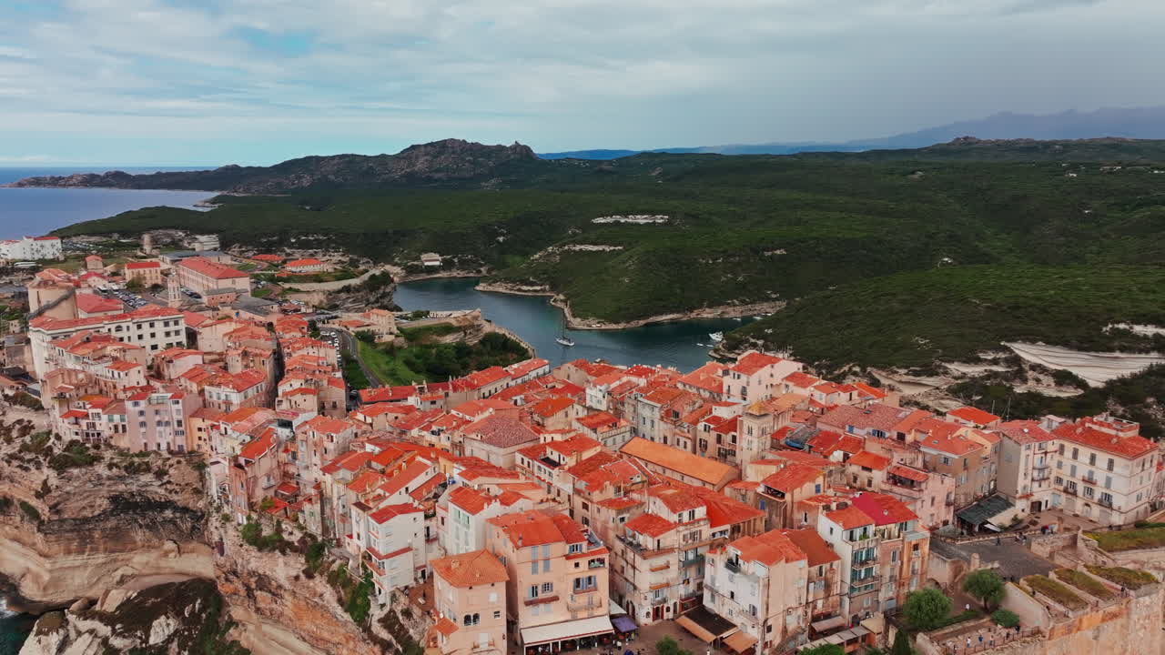 Ripresa aerea con drone della storica città costiera di Bonifacio in Corsica, Francia. Vista dall'alto della ripida scogliera rocciosa e del mare turchese. Antica cittadella con vista sulla costa frastagliata