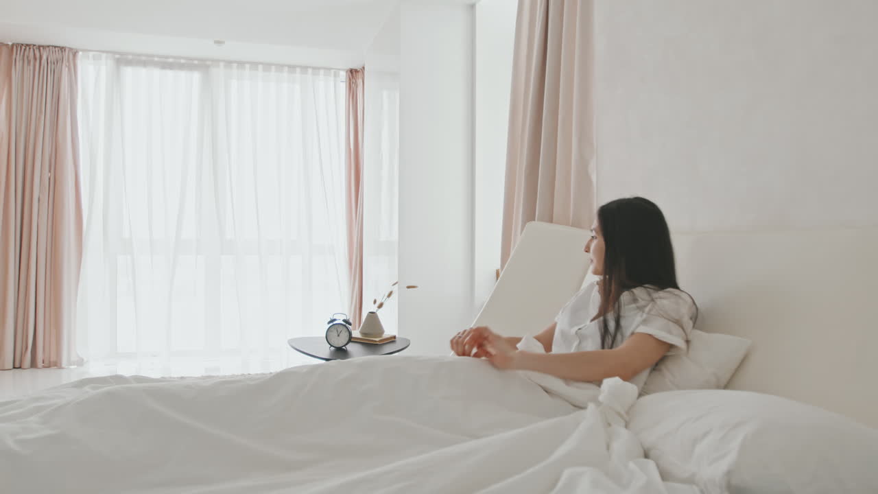 Beautiful Young Woman Waking Up In Modern Light Bedroom