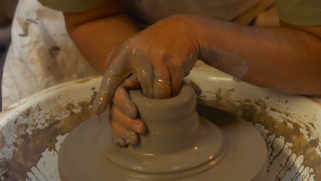 potter making a earthen pot on a pottery wheel