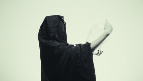 woman in black cloak with glass skull