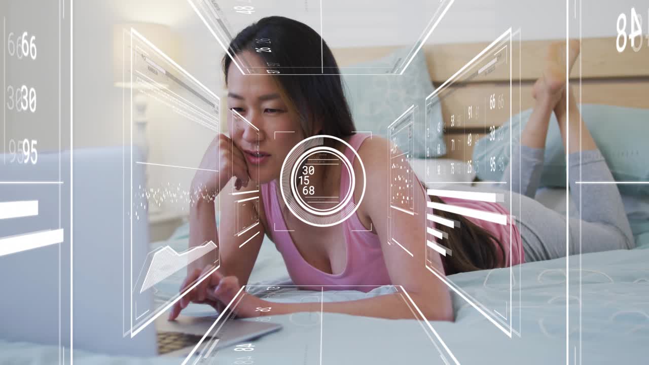 Mid adult woman powering on laptop and analyzing business data with translucent floating charts