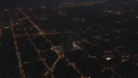 Los-Delanteros-Vuelan-Alto-Sobre-La-Ciudad-Nocturna.-Calles-Iluminadas-En-El-Centro-Histórico-De-La-Ciudad.-Basílica-Sagrada-Familia.-Barcelona,-España