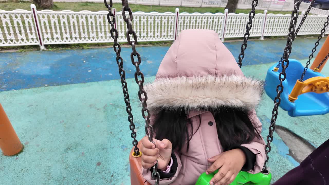 A child enjoying a swing in a playground