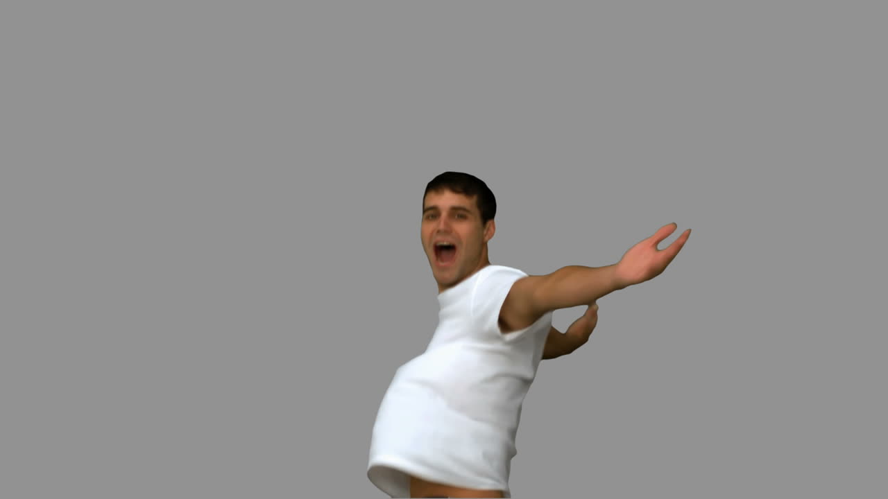 Handsome man turning and raising arms on grey screen