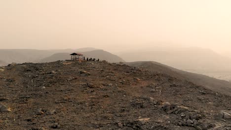 Mountain-biking-checkpoint-stop-over-with-a-wooden-hut-at-the-top-of-the-mountain-with-silhouette-of-bikers-getting-ready