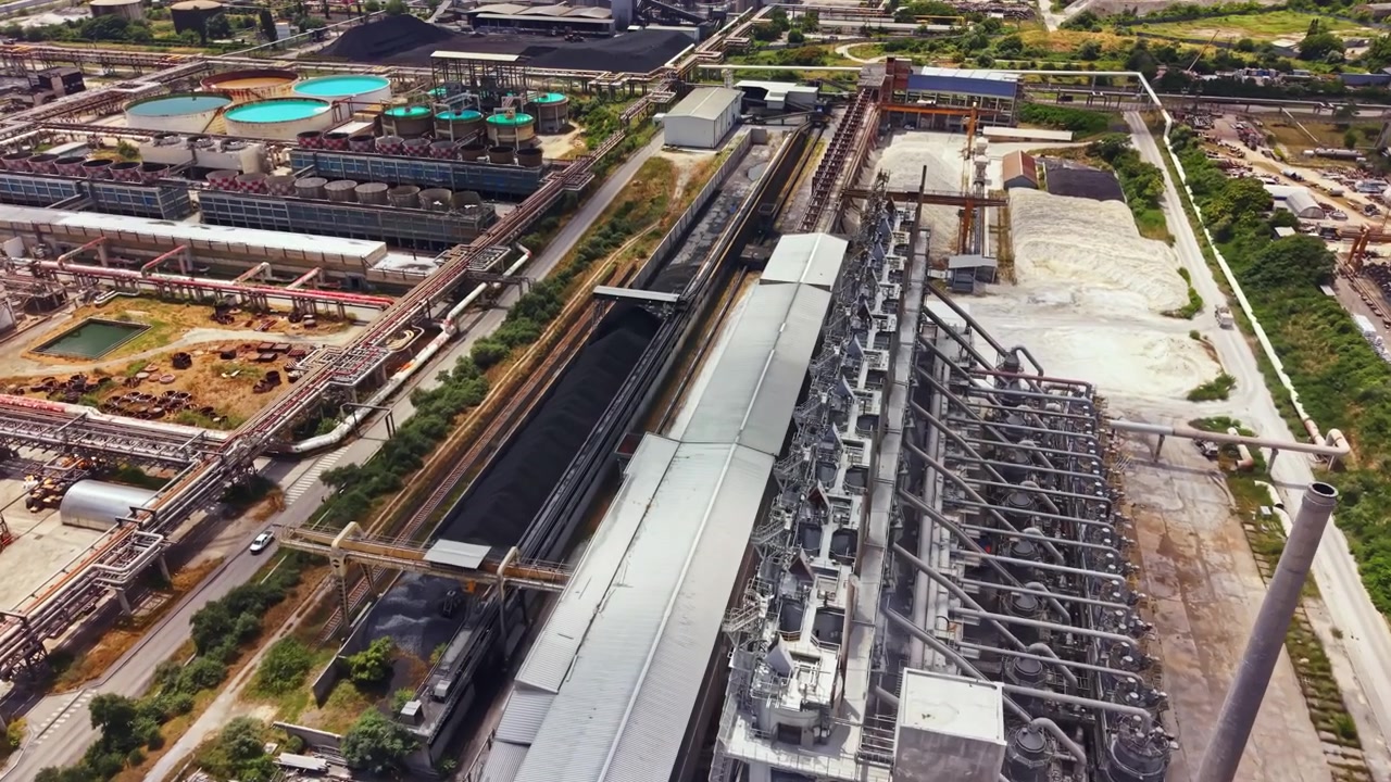 Sito di industria pesante con macchinari e strutture visti dall'alto in un'area vivace con vari edifici e attrezzature a mezzogiorno