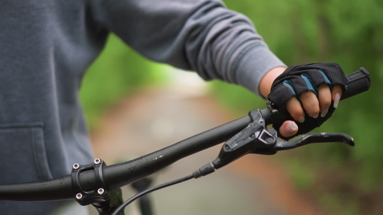 Inspecting Handlebar Brake For Proper Function, Close View Of Rider Testing Brake Response Carefully, Detailed Examination Of Handlebar Brake Mechanism During Safety Check On Trail