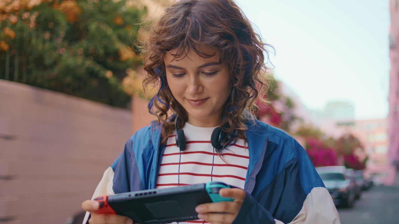 teen disfruta de videojuegos portátiles en la calle de cerca. consola portátil centrada en niñas