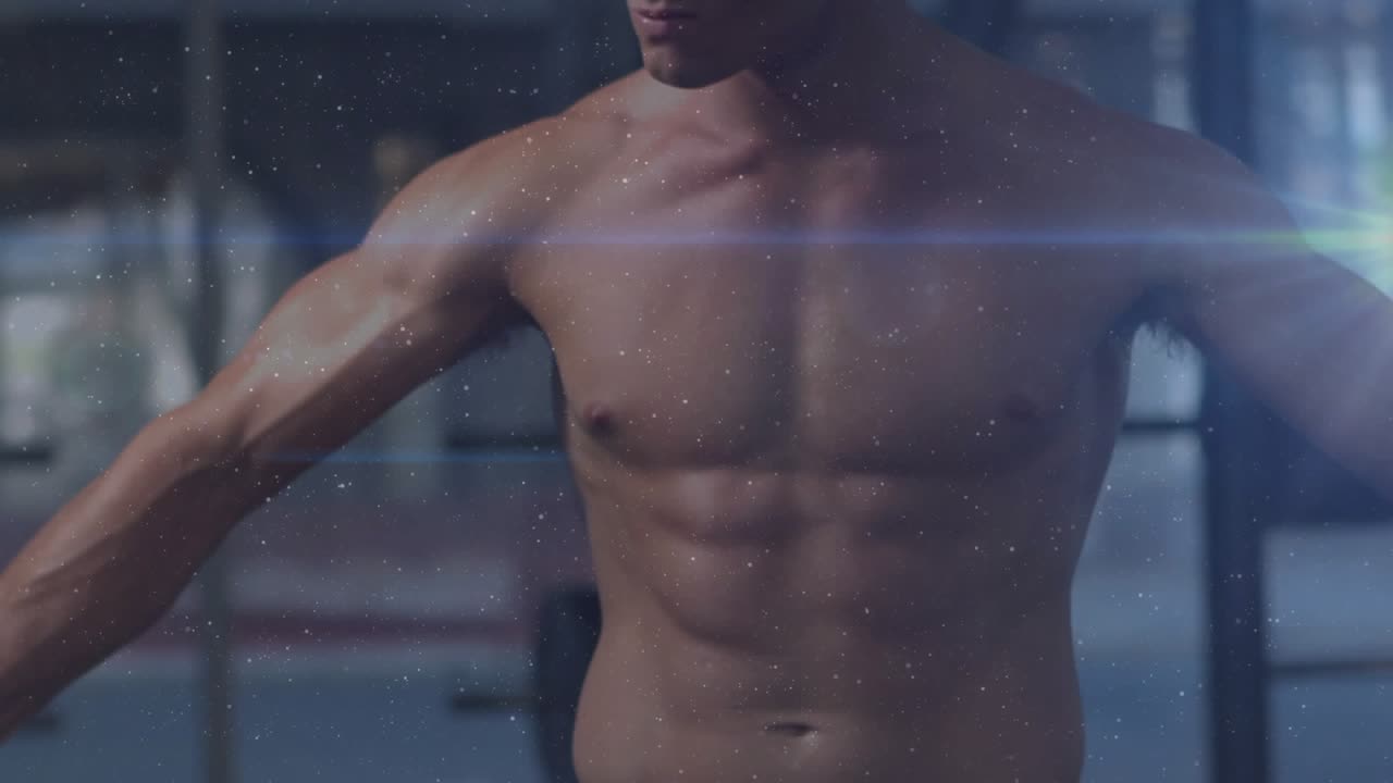 Fitness model rotating torso, holding pose in gym, camera shift overlaying flares and dust for ad