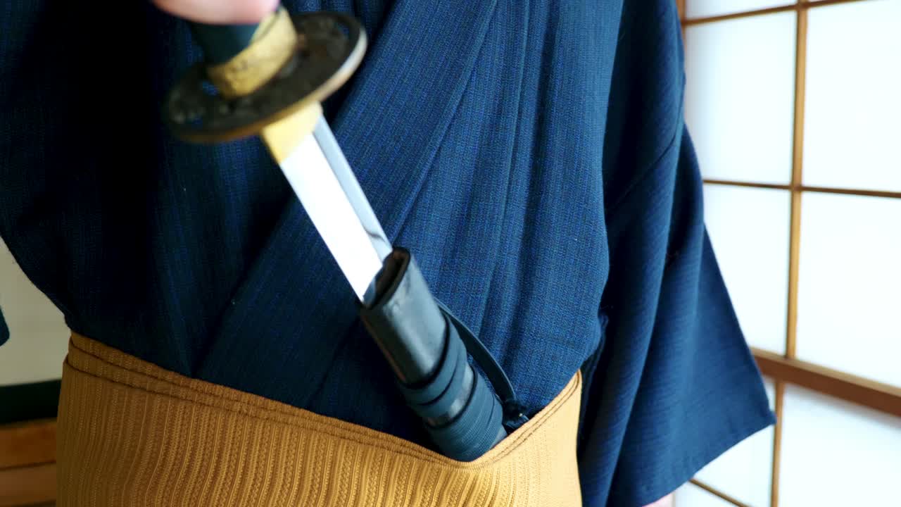 A Man in a Traditional Japanese Kimono with a Samurai's Katana Sword in an Old Traditional Japanese House in Slow Motion