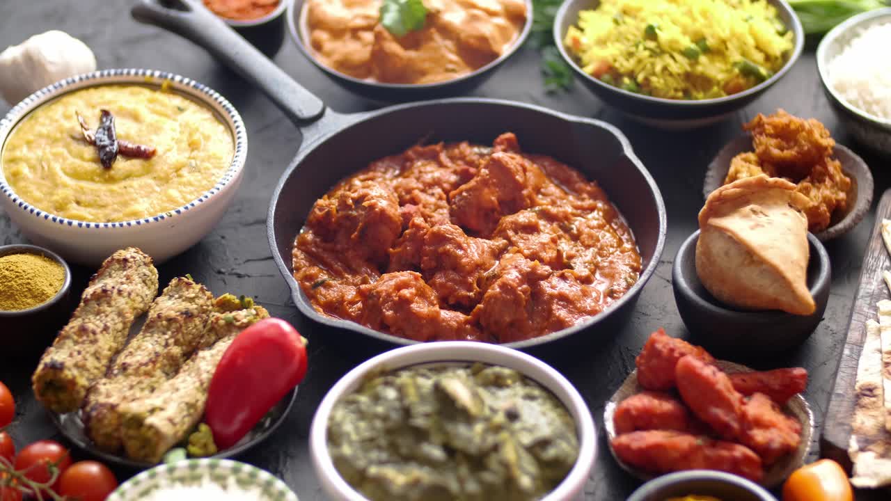 varios platos indios en una mesa pollo picante tikka masala en sartén de hierro