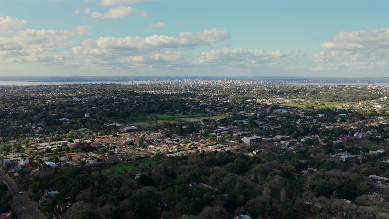 Ampio panorama aereo rivela quartieri residenziali che si estendono verso lo skyline distante di Posadas, Argentina