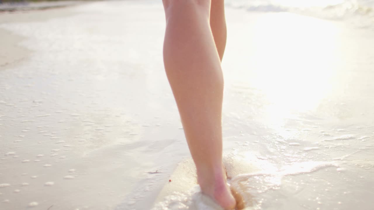Gambe di donna caucasica a piedi nudi che si gode il tramonto sull'isola.
