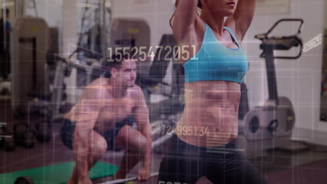 workout partners raising arms and squatting on green mat in gym, displaying fitness data overlay