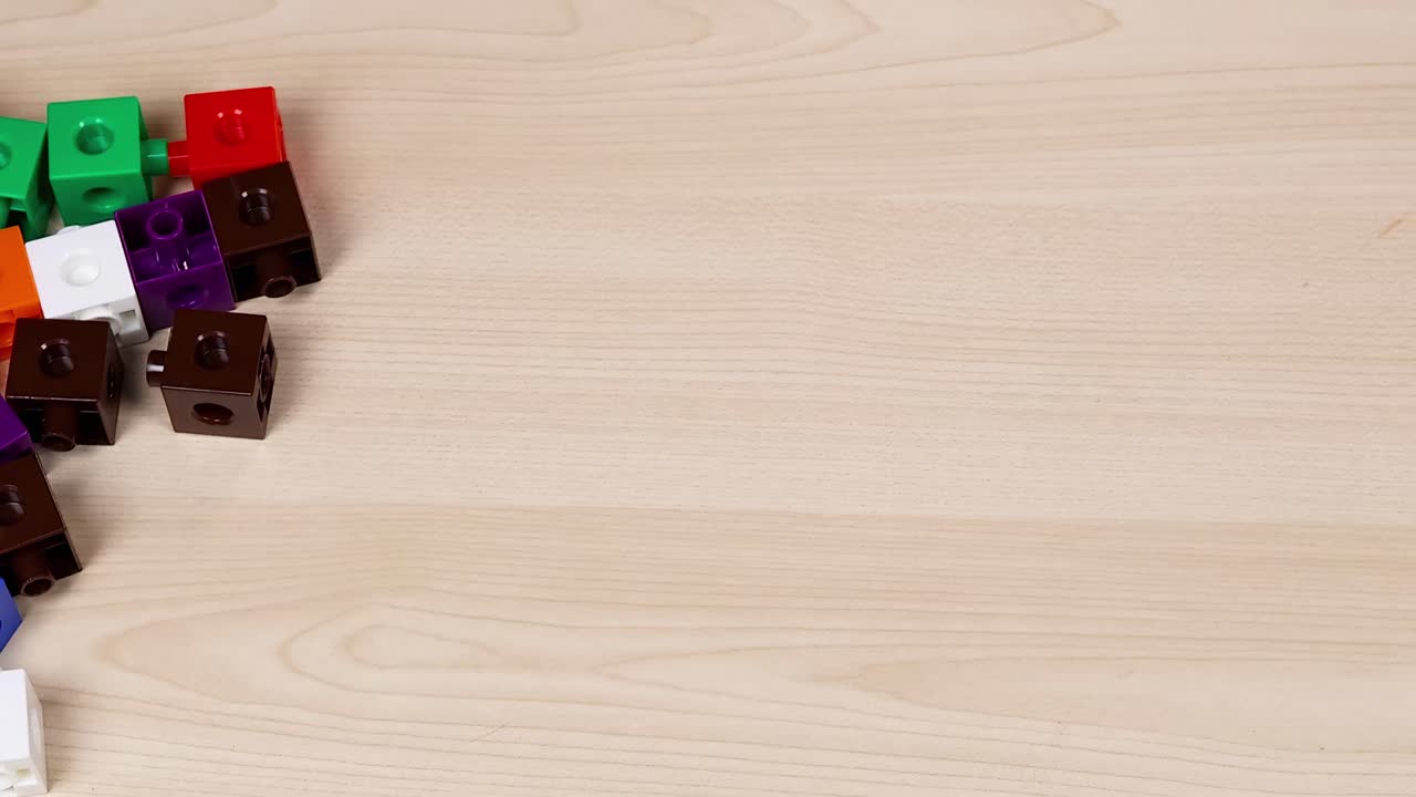 manos organizando cubos coloridos en una mesa de madera