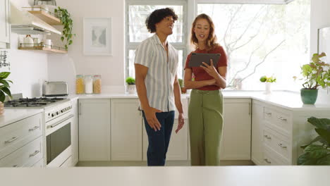 planning kitchen renovation, diverse couple using digital tablet to discuss design ideas, at home