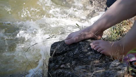 woman feet on rock at lake