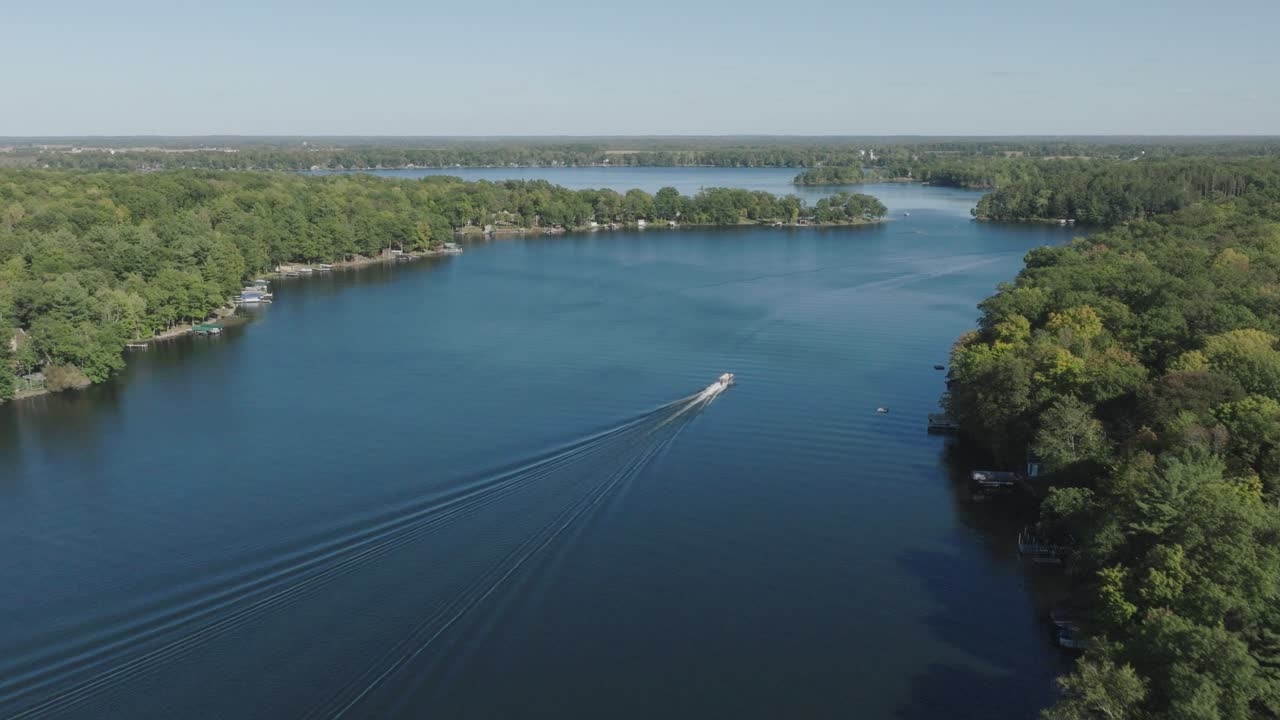 vista aérea de un barco de pontón que navega en el lago balsam, wisconsin, rodeado de vegetación.