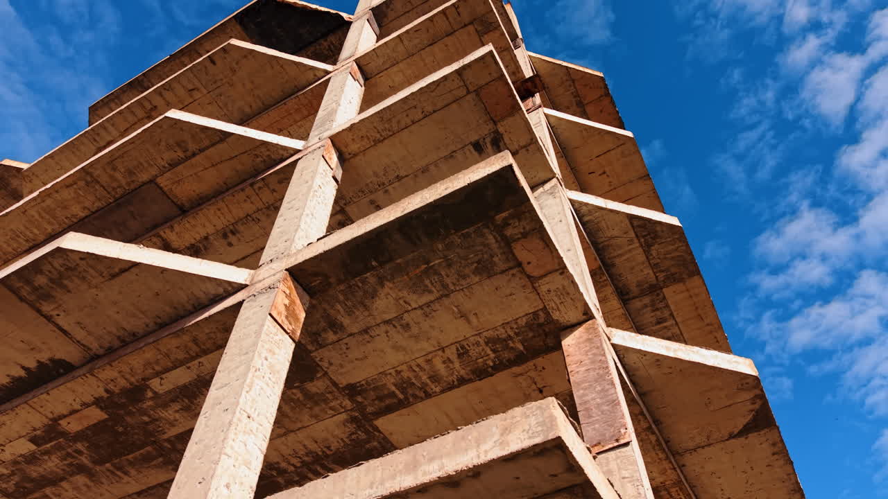 Etagen des mehrstöckigen Gebäudes. Froschperspektive auf die Baustelle vor blauem Himmel