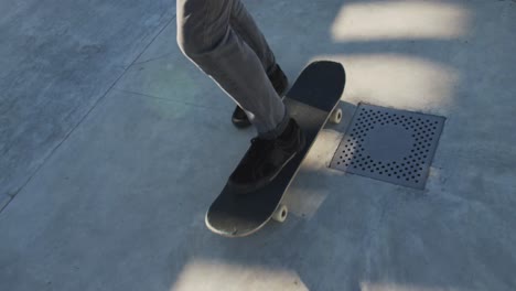 low section of caucasian man skateboarding at a skatepark