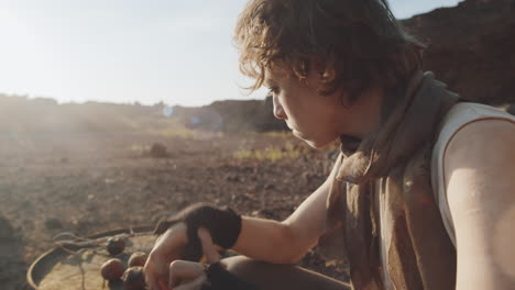 woman in dirty worn clothes eating apples in dystopian world