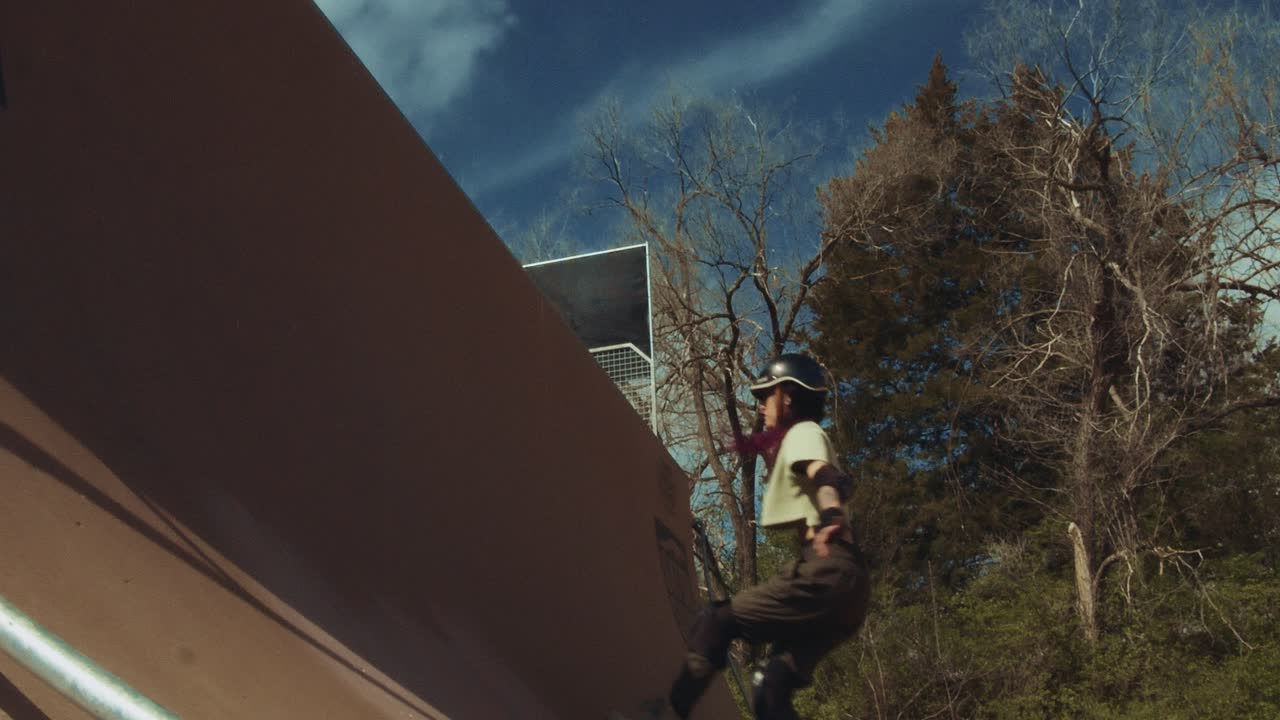Slowmotion af rulleskøjteløber, der pumper og hopper på en høj halfpipe