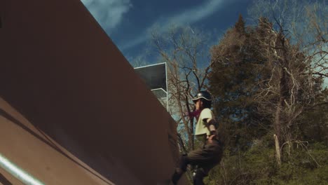 slow motion of quad skater pumping and jumping on a tall half-pipe