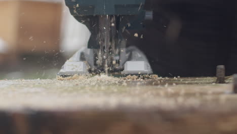 handheld slow-motion shot of jigsaw cutting a board