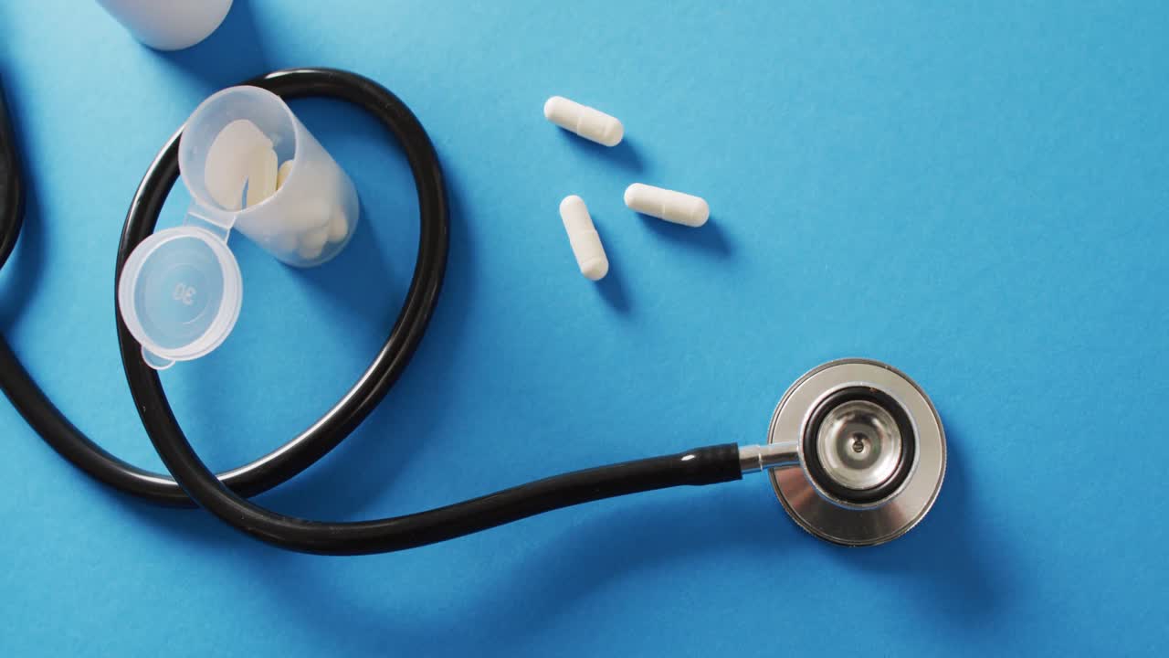 Video di stetoscopio con pillole su sfondo blu con spazio per il testo