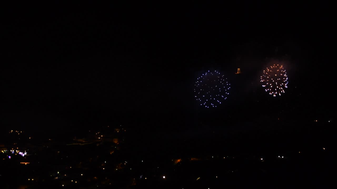 밤에 산 마을에서 많은 금빛과 반짝이는 불꽃놀이로 축하